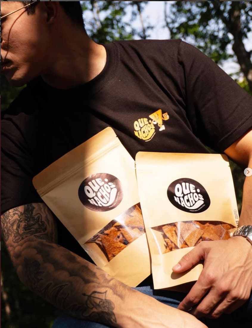 Chico con dos bolsas kraft de Que Nachos